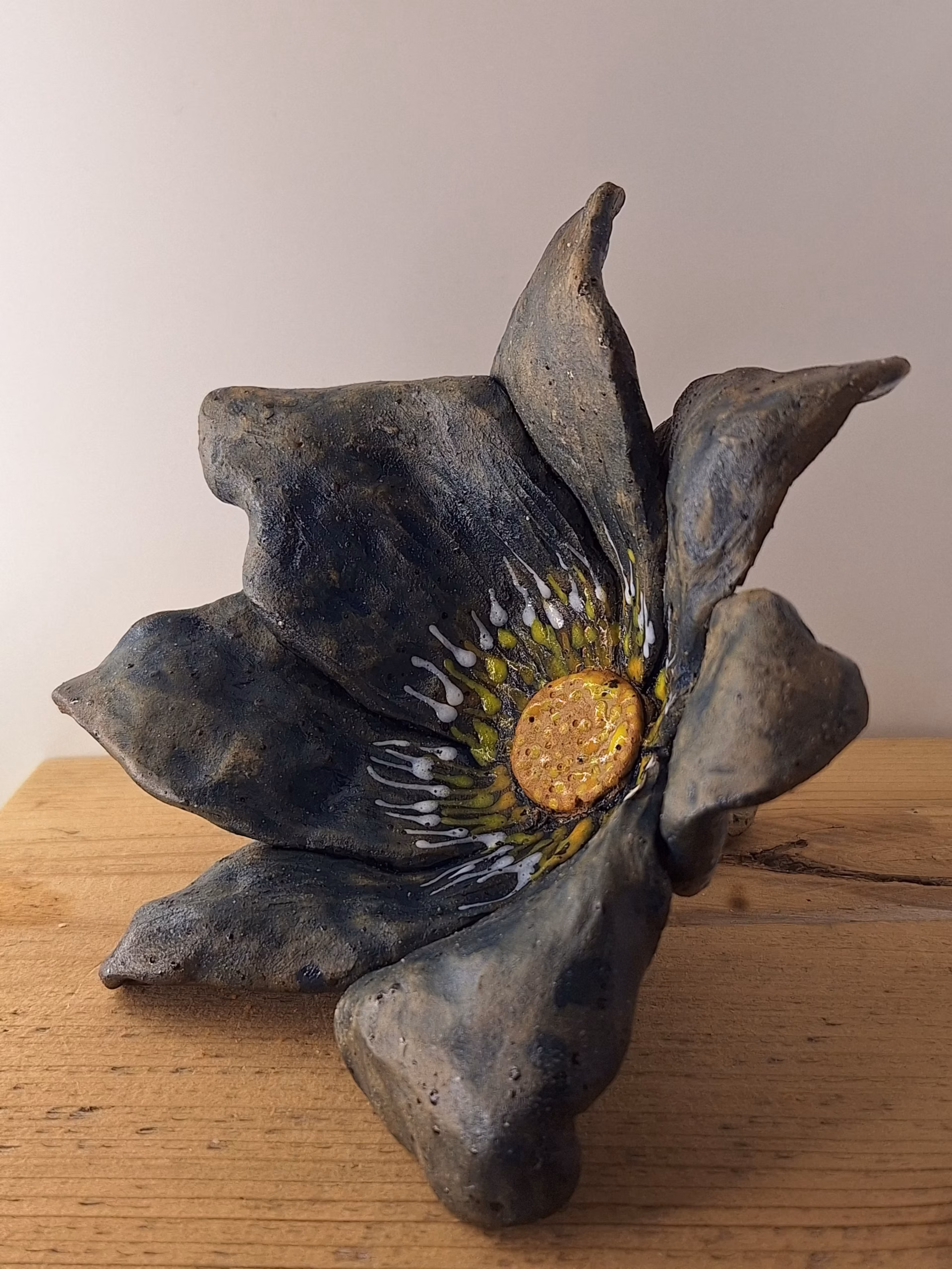 Small ceramic fairy house shaped like a bulbous acorn with deep wood-grain texture, deep blue draped fabric, curved hook stem, and a small heart-shaped door.