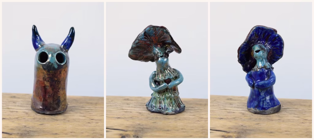 Three raku-fired pieces: the horned Raku Fire Demon, Prudence with a copper mushroom cap, and Daphne in deep cobalt blue