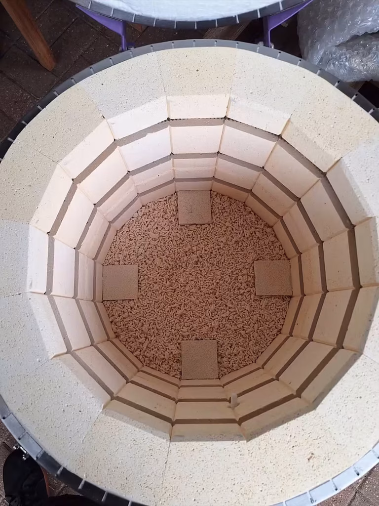 Looking down into the empty kiln chamber, lined with pale firebrick